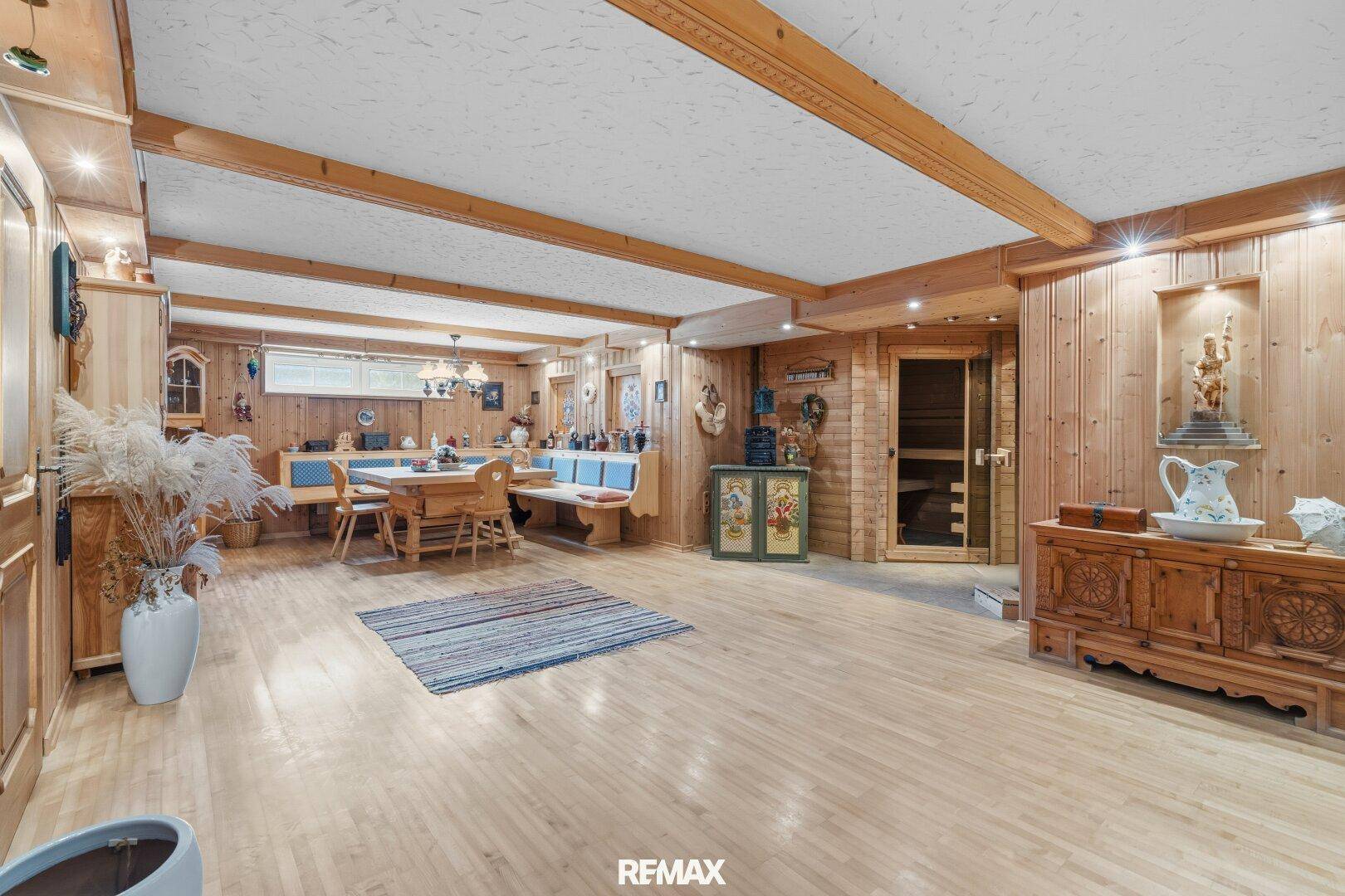 Rustikaler Kellerraum mit Holzvertäfelung, Essbereich und Sauna-Zugang.