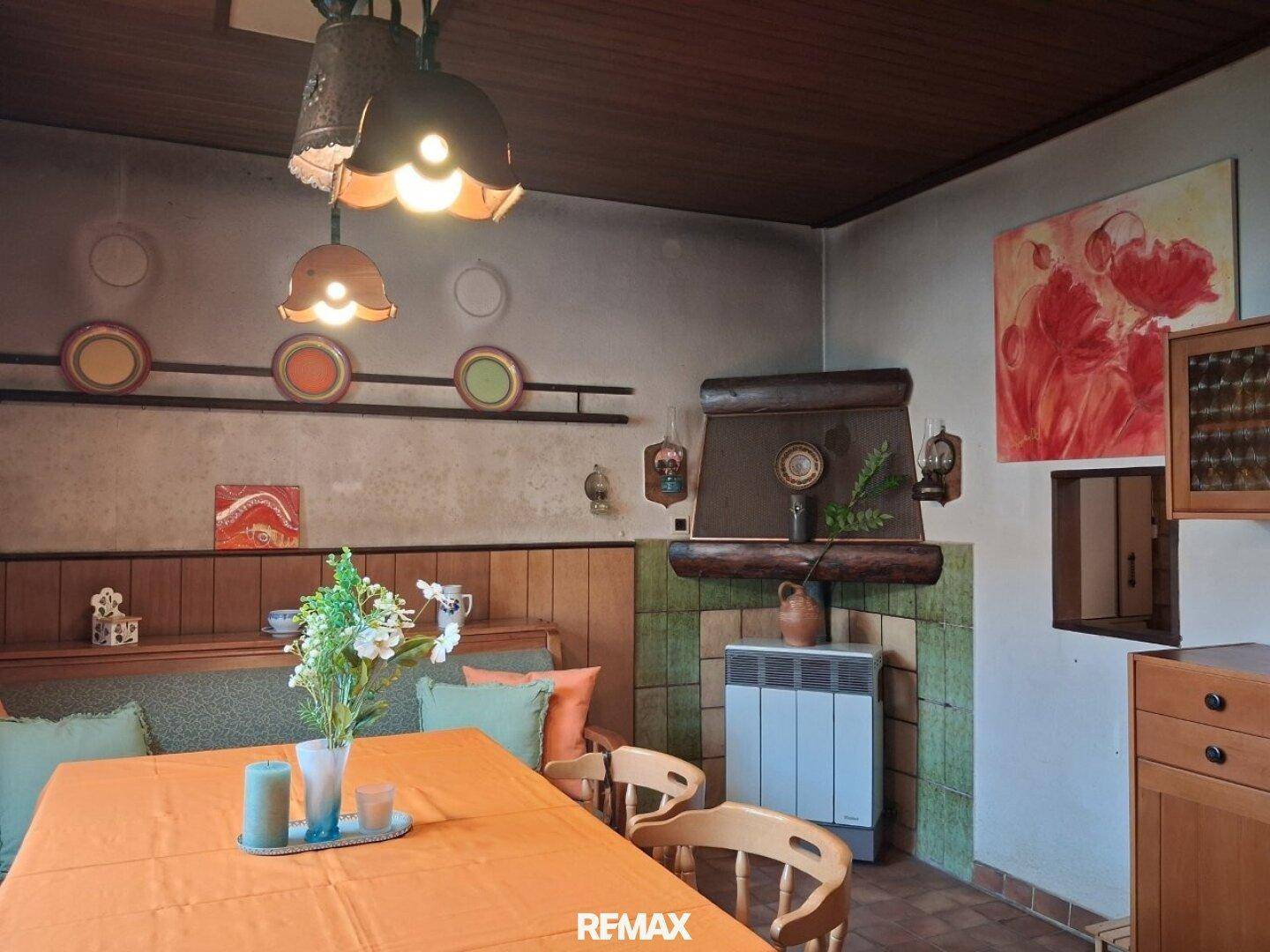 Gemütlicher Essbereich mit Holztäfelung, rustikalem Kamin und traditioneller Deckenverkleidung.