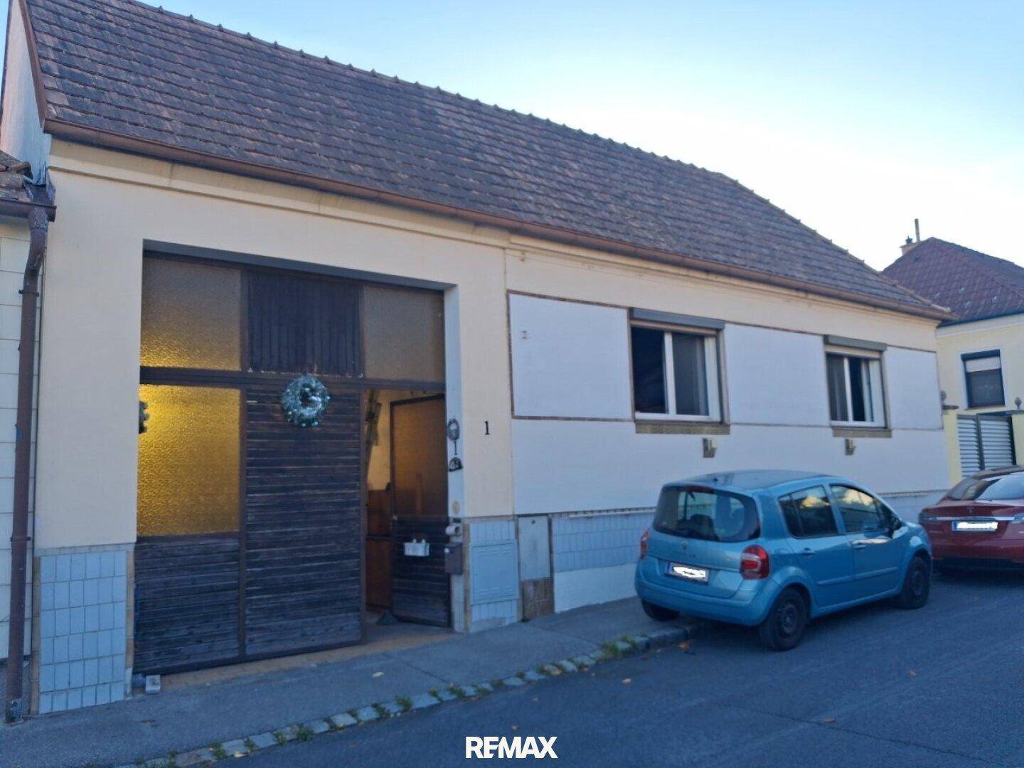 Außenansicht des Gebäudes von der Straße mit traditionellem Satteldach und einem geparkten Auto davor.