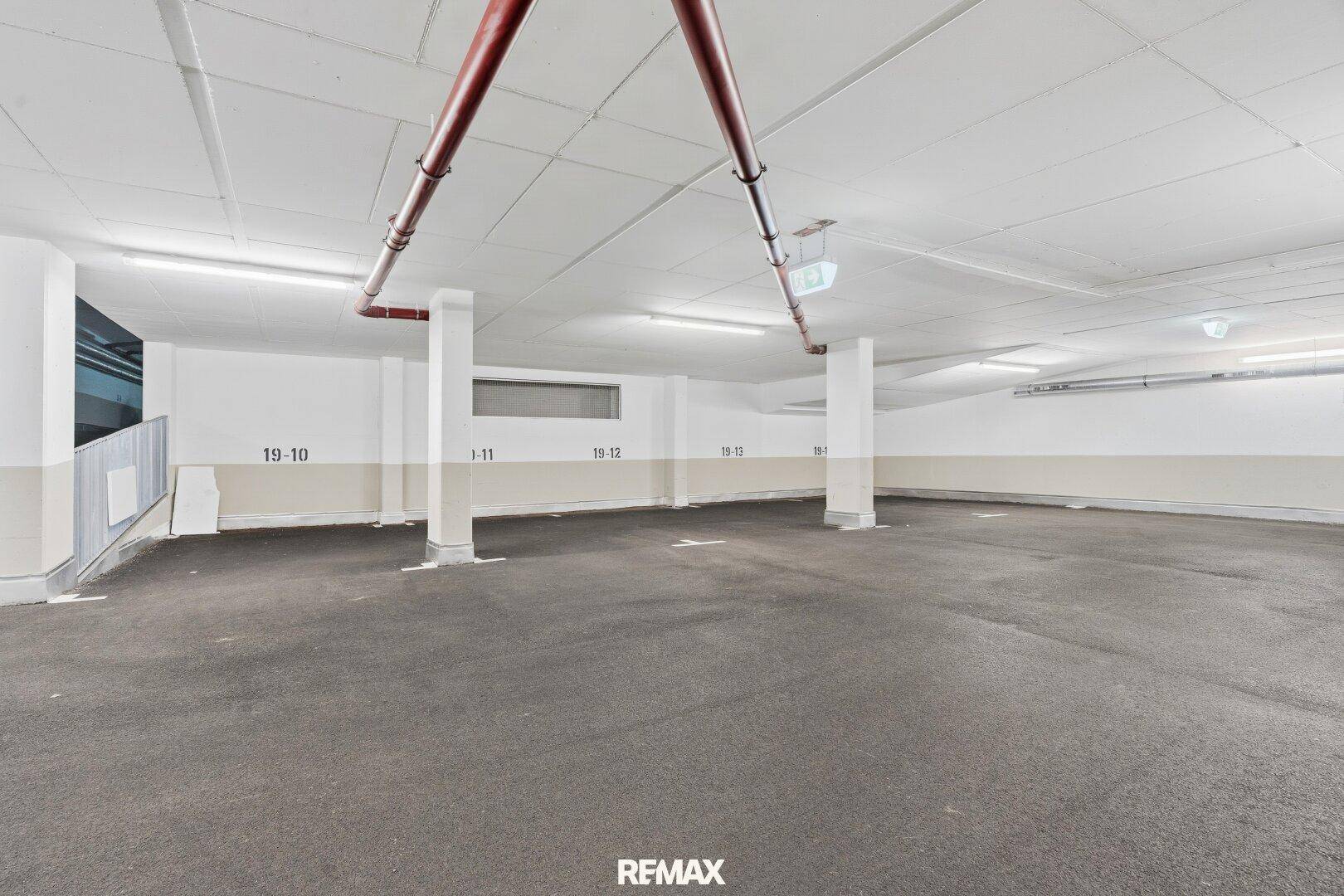 Geräumige Tiefgarage mit markierten Stellplätzen und guter Beleuchtung.