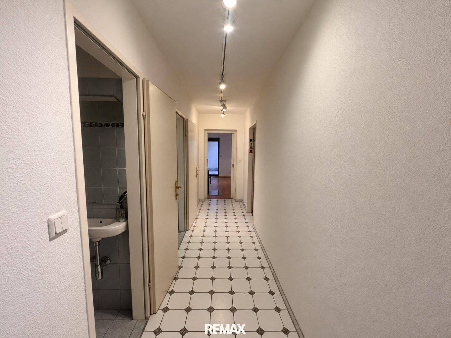 Langer Flur mit gemusterten Fliesen und Blick auf weitere Zimmer.