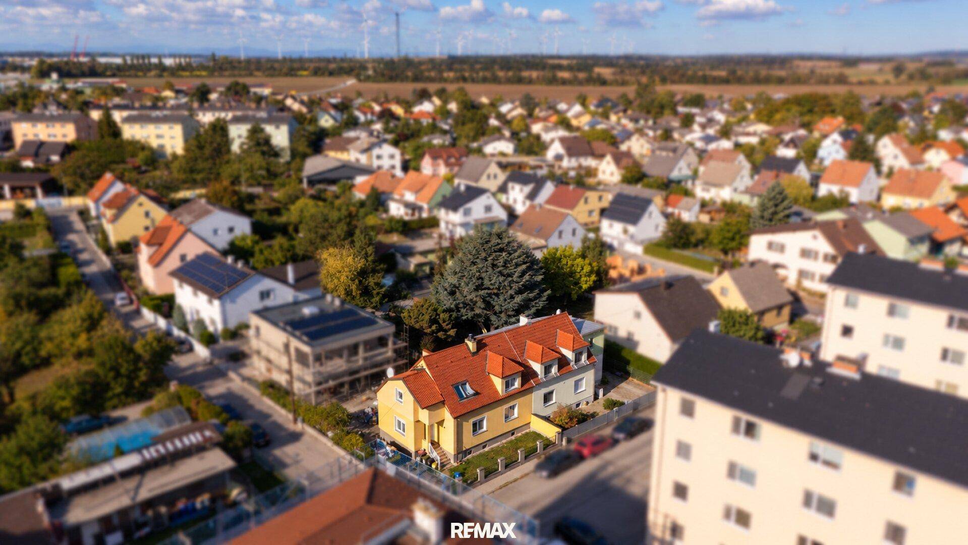Weitläufige Luftaufnahme des Einfamilienhauses in einer ruhigen Wohnsiedlung mit Fernblick.