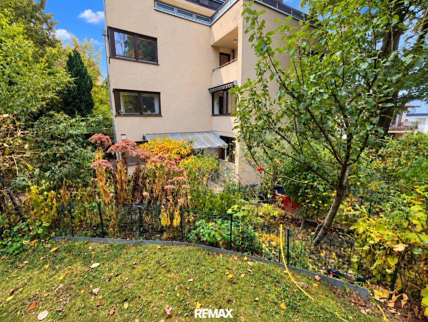 Gartenbereich mit Rasen und Blick auf die Rückseite des Wohngebäudes.