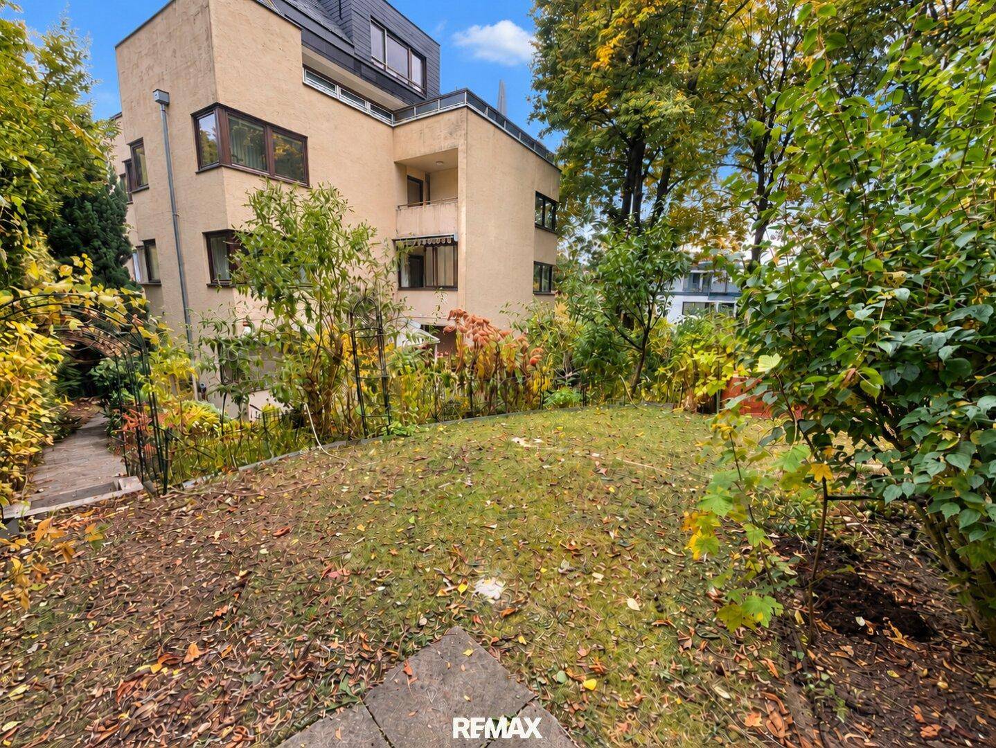 Große Rasenfläche im Garten mit Blick auf das Mehrfamilienhaus.