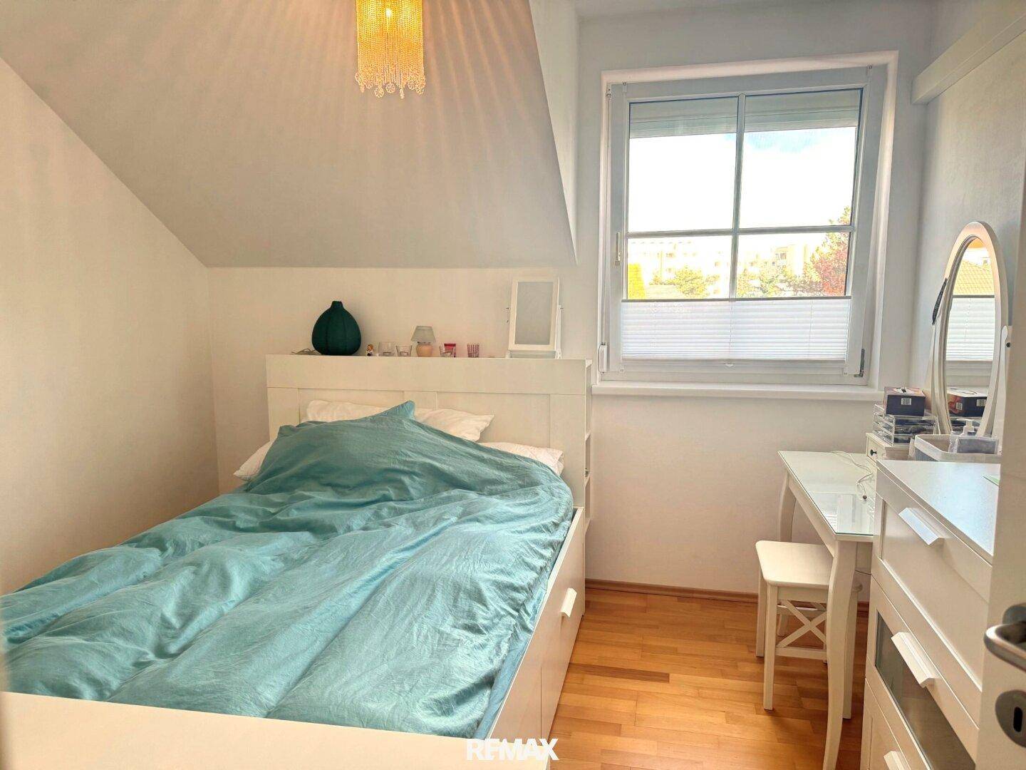 Kinderzimmer oder Gästezimmer mit Einzelbett, Schreibtisch und Fenster im Dachgeschoss.