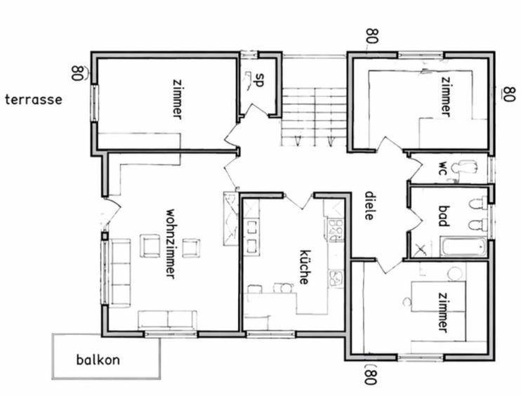 Grundriss des Erdgeschosses mit Wohnzimmer, Küche, Schlafzimmern, Bad und Zugang zu Balkon und Terrasse.