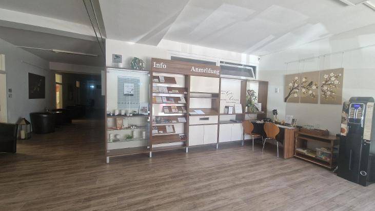 Empfangsbereich mit Informationsschalter, Anmeldetresen und Ausstellungsregalen für Produkte.