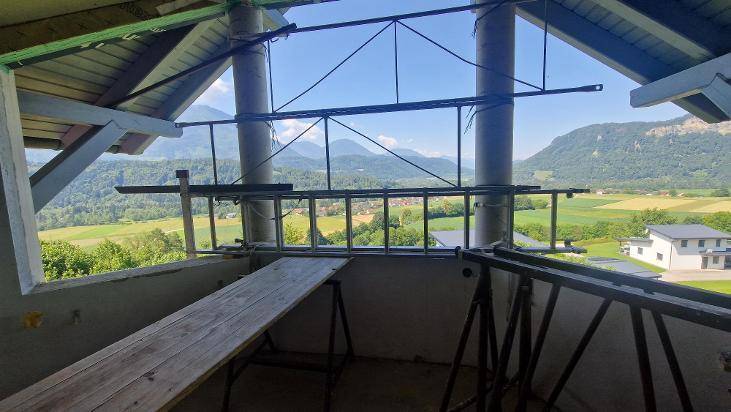 Unfertiger Raum mit Gerüst und weitem Panoramablick auf Berge und das grüne Tal.