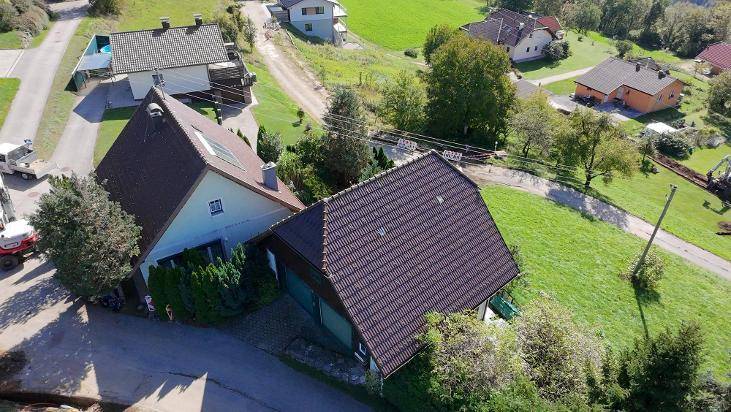 Schrägansicht von oben auf das Wohnhaus mit Nebengebäude und gepflegtem Gartenbereich.