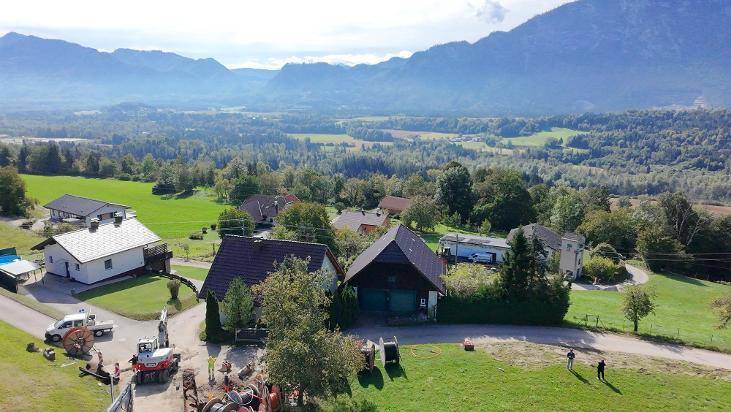 Weitläufige Ansicht des Anwesens mit Bergblick und umliegender grüner Landschaft unter blauem Himmel.