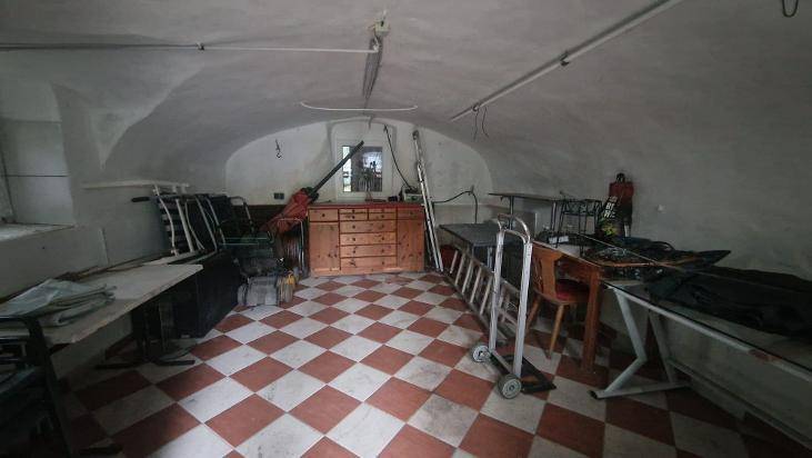 Geräumiger Kellerraum mit gewölbter Decke, Fliesenboden und verschiedenen Lagergegenständen.