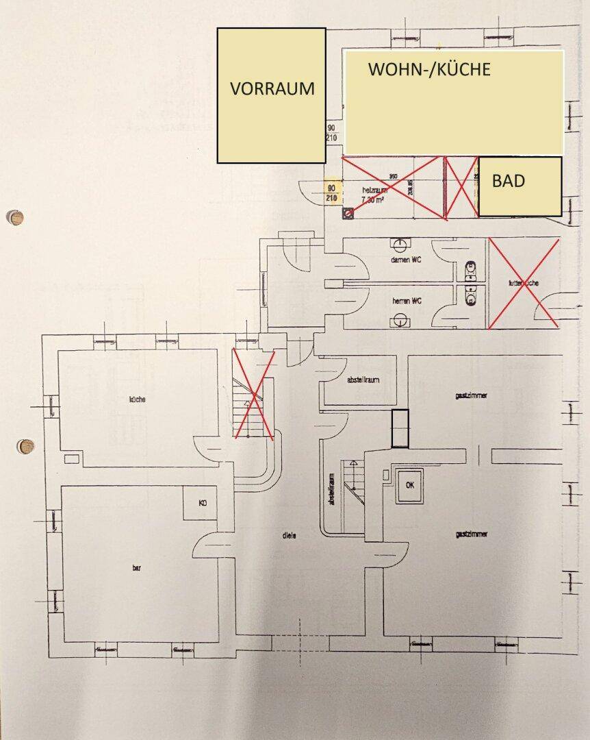 Grundriss mit eingezeichneten Bereichen für Vorraum, Wohnküche und Bad sowie Toiletten.