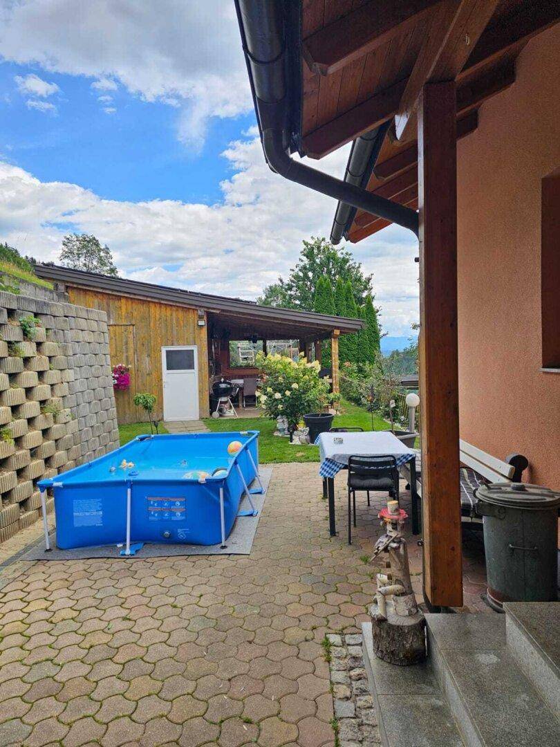 Außenbereich mit aufstellbarem Pool, Esstisch und überdachtem Bereich, ideal für sommerliche Aktivitäten.