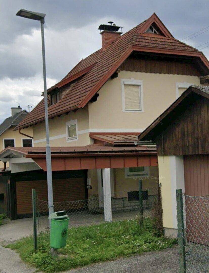 Vorderansicht des Hauses mit Satteldach und Carport von der Straße aus.