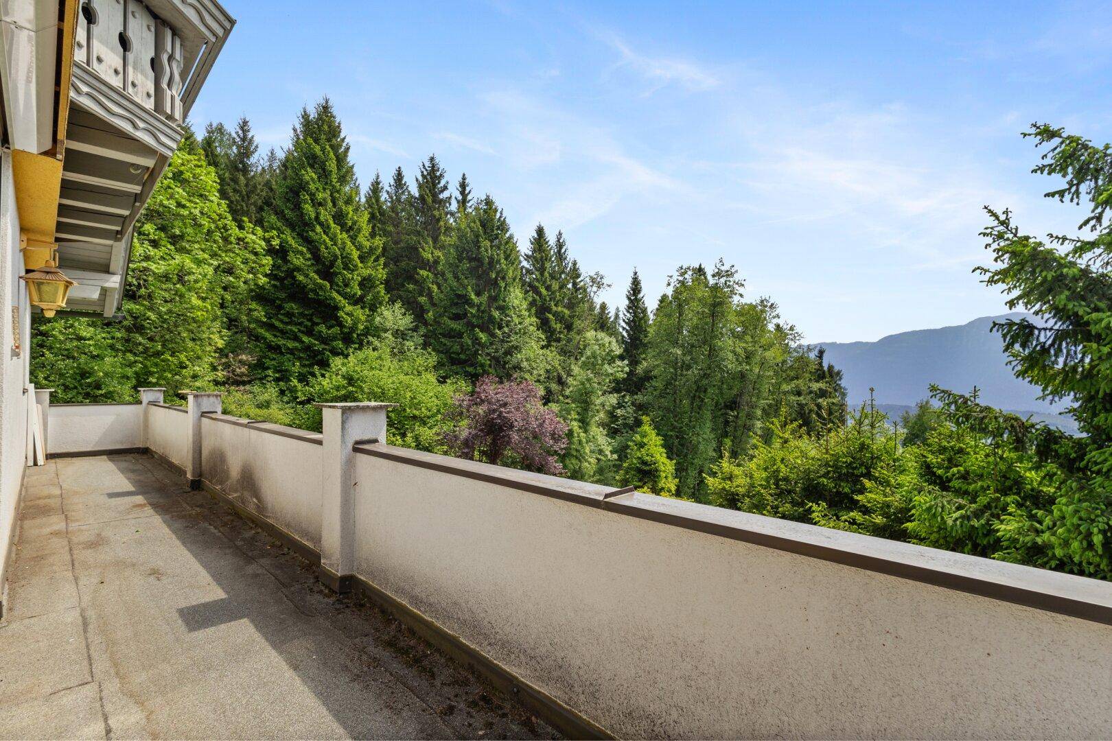 Weitläufige Dachterrasse mit Panoramablick auf die grüne Umgebung und Berge.