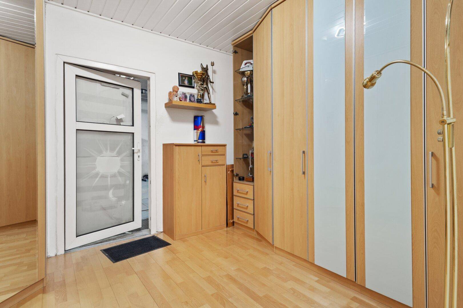 Flur mit Einbauschränken, Holzfußboden und Zugang zu weiteren Räumen.