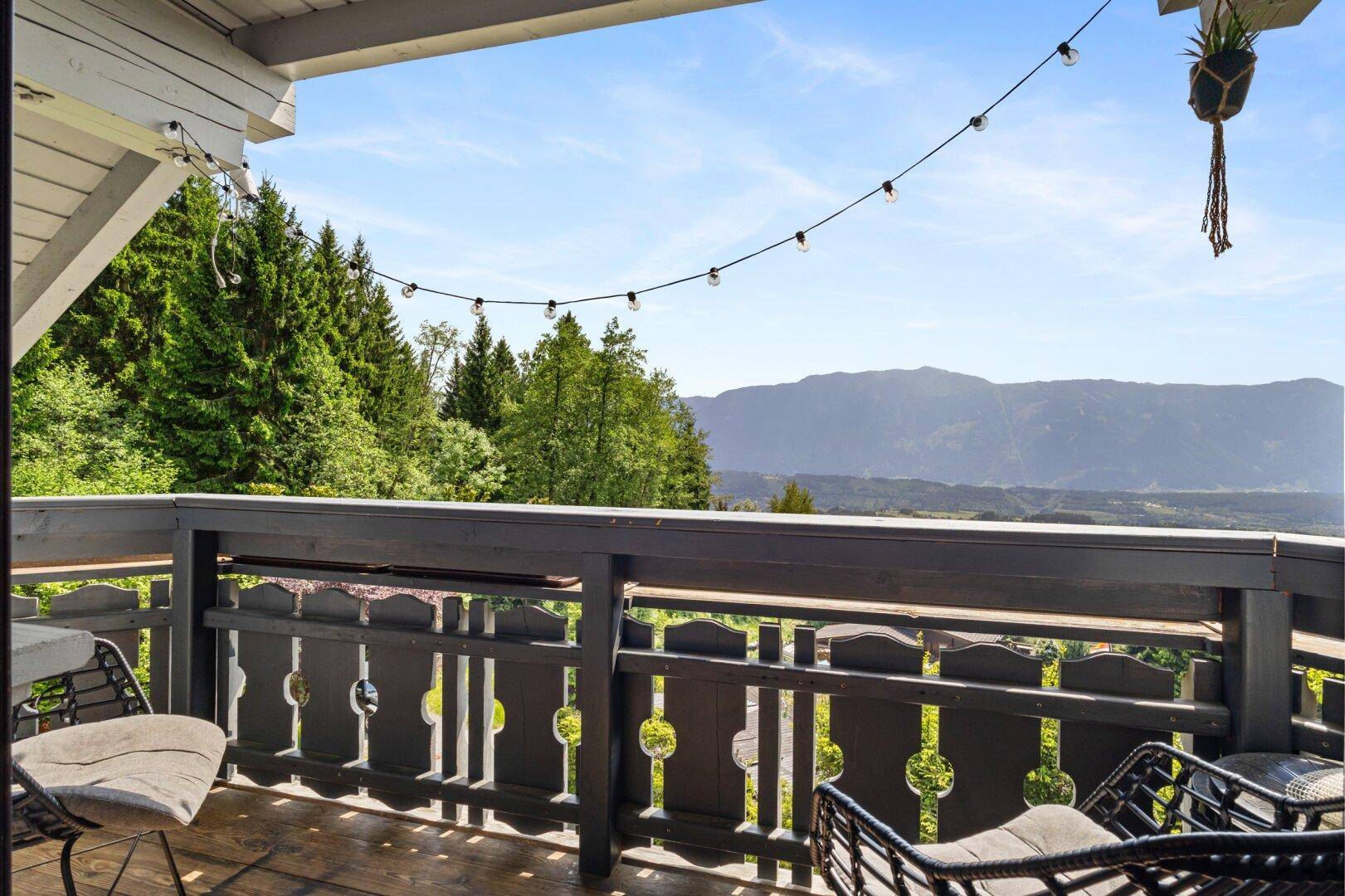 Balkon mit Sitzgelegenheiten und einem weiten Blick auf die umliegende Berglandschaft.