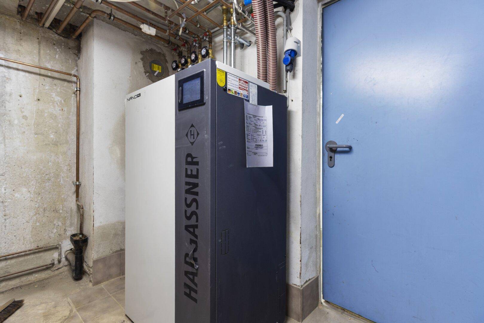 Heizungsraum mit moderner Heizungsanlage und sichtbaren Rohrleitungen.