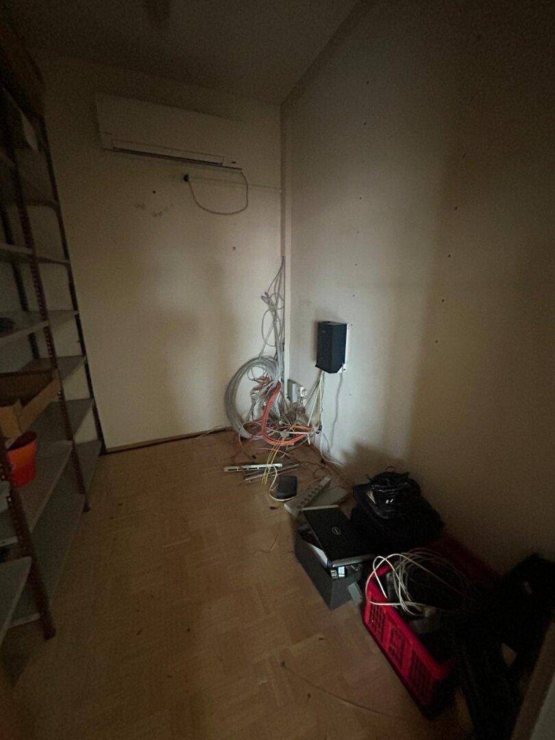 Abstellraum mit Regalen und sichtbaren Kabelinstallationen, möglicherweise ein Technikraum.