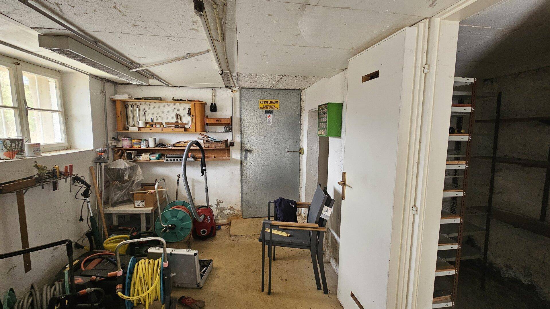 Geräumiger Kellerraum, der als Werkstatt und Lagerbereich mit verschiedenen Geräten dient.