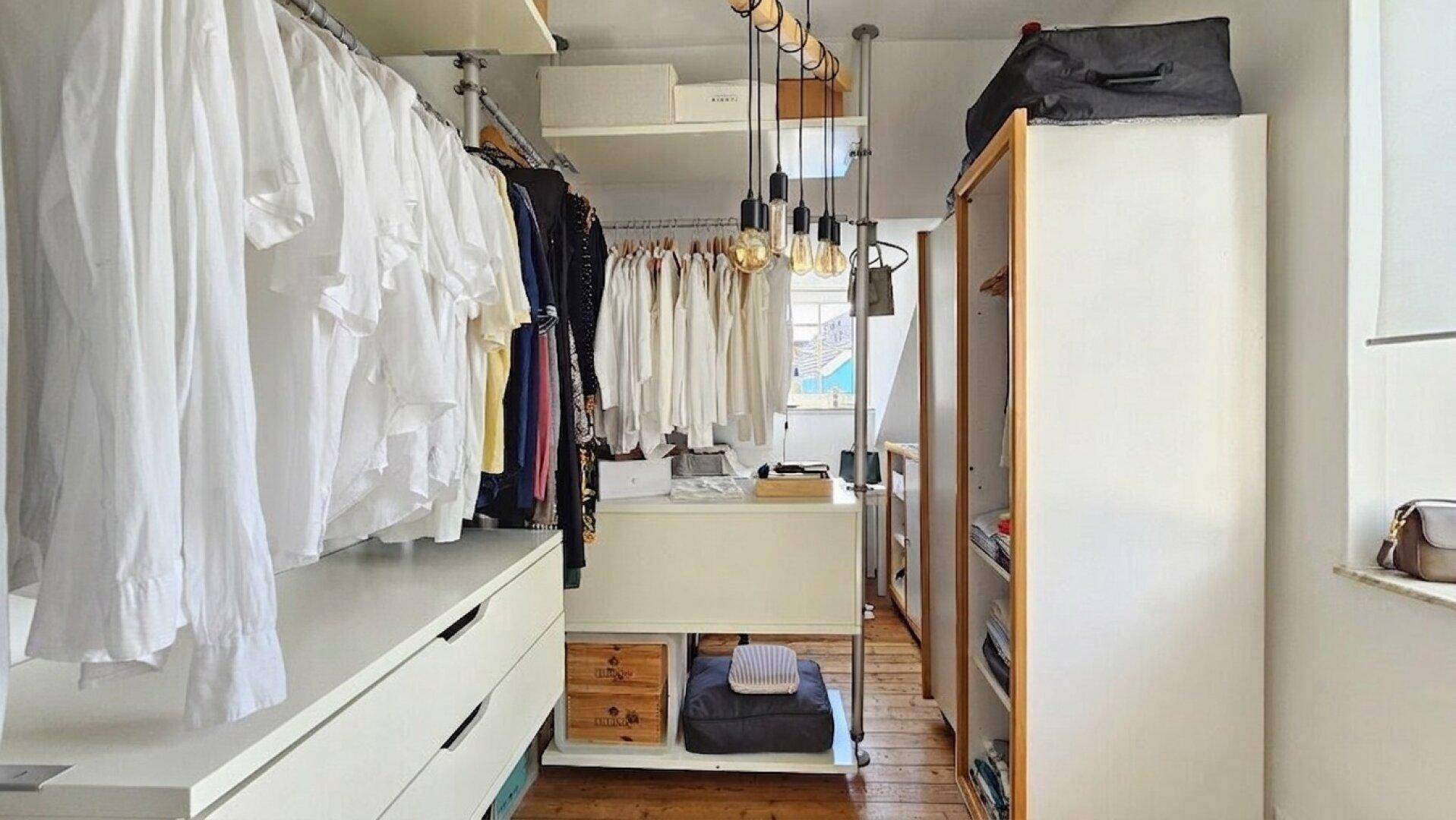 Geräumiger begehbarer Kleiderschrank mit offenen Regalen, Kleiderstangen und viel Stauraum.