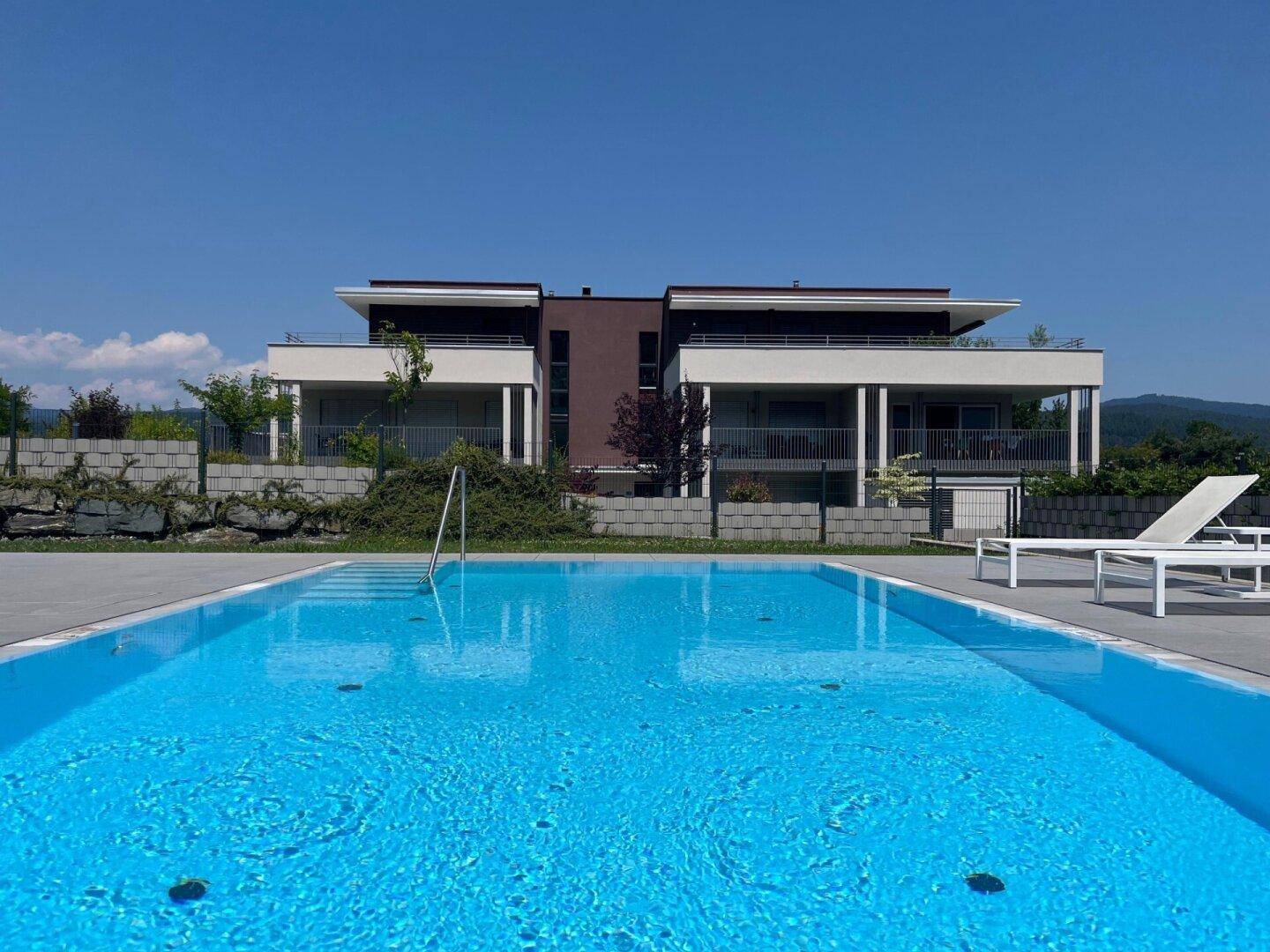Großer Außenpool mit Blick auf die moderne Architektur des Gebäudes und die umliegende Landschaft.