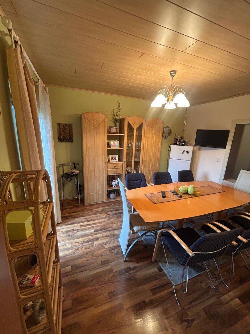 Geräumiger Essbereich mit großem Holztisch und passenden Holzschränken.