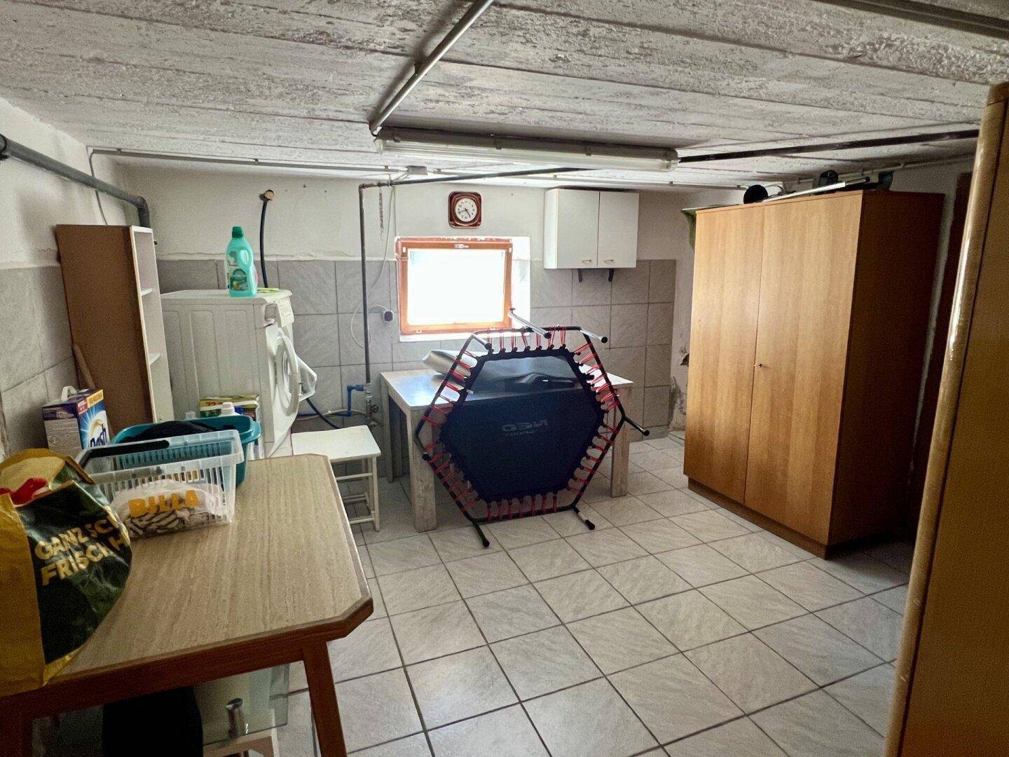 Hauswirtschaftsraum mit Waschmaschine, Trockner und Stauraum.