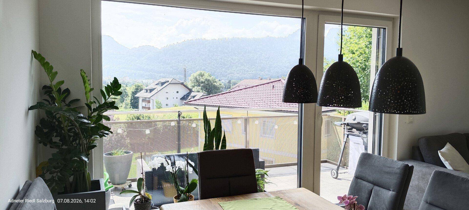 Essbereich mit modernen Pendelleuchten und Panoramablick auf die umliegende Berglandschaft.