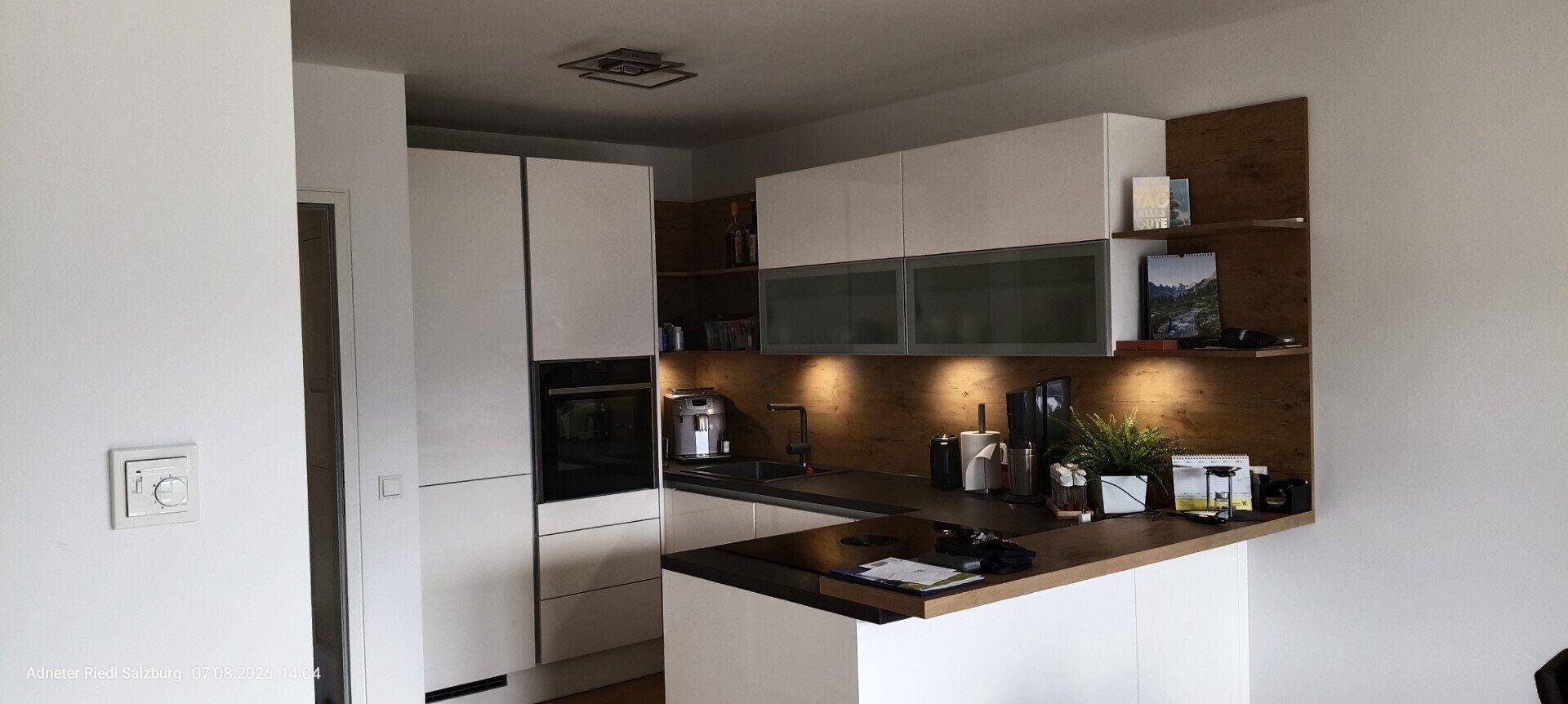 Detailansicht der modernen Küche mit integriertem Backofen und stilvoller Beleuchtung.