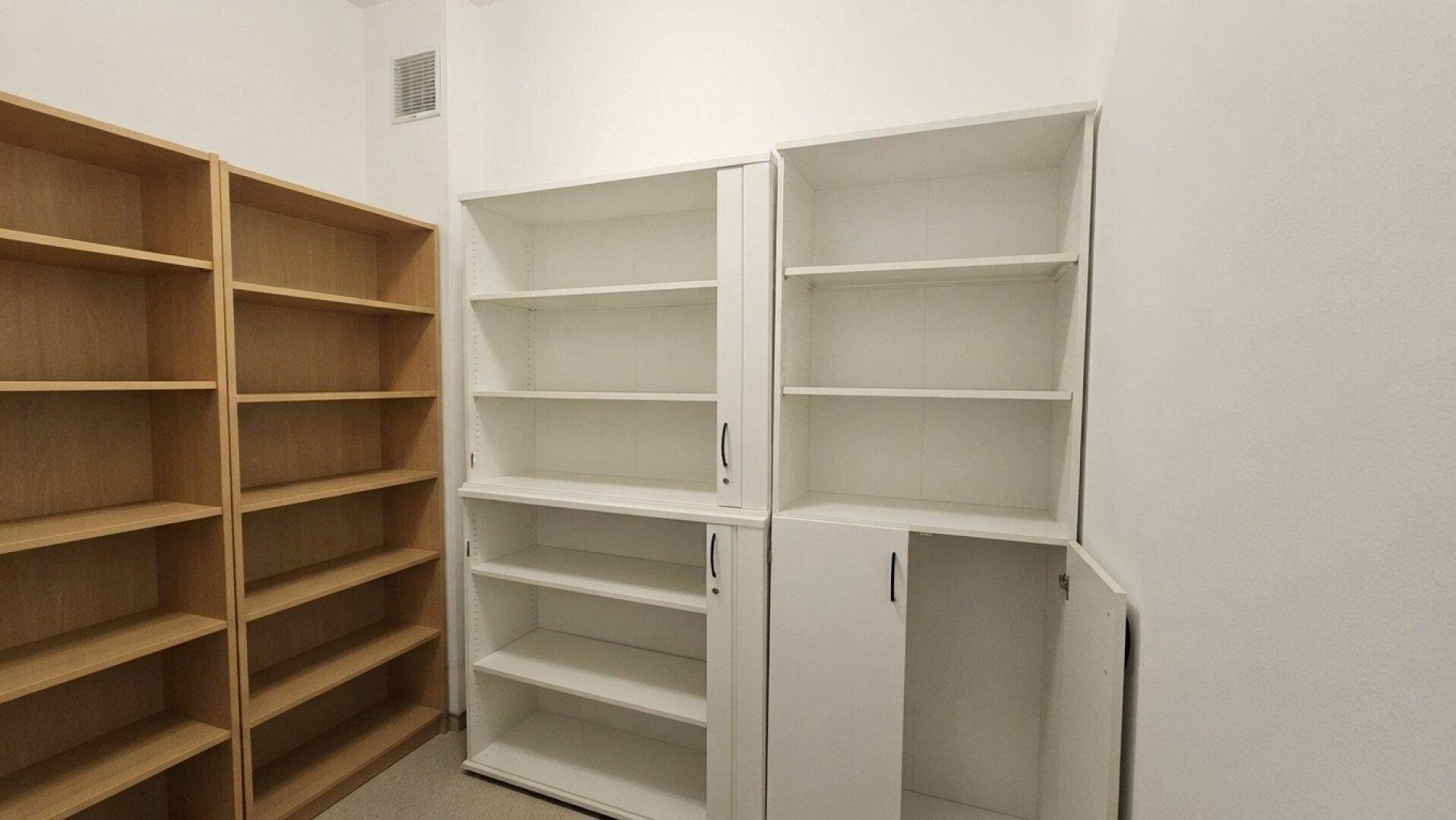 Lagerraum mit verschiedenen leeren Regalen und Schränken für Bürobedarf.