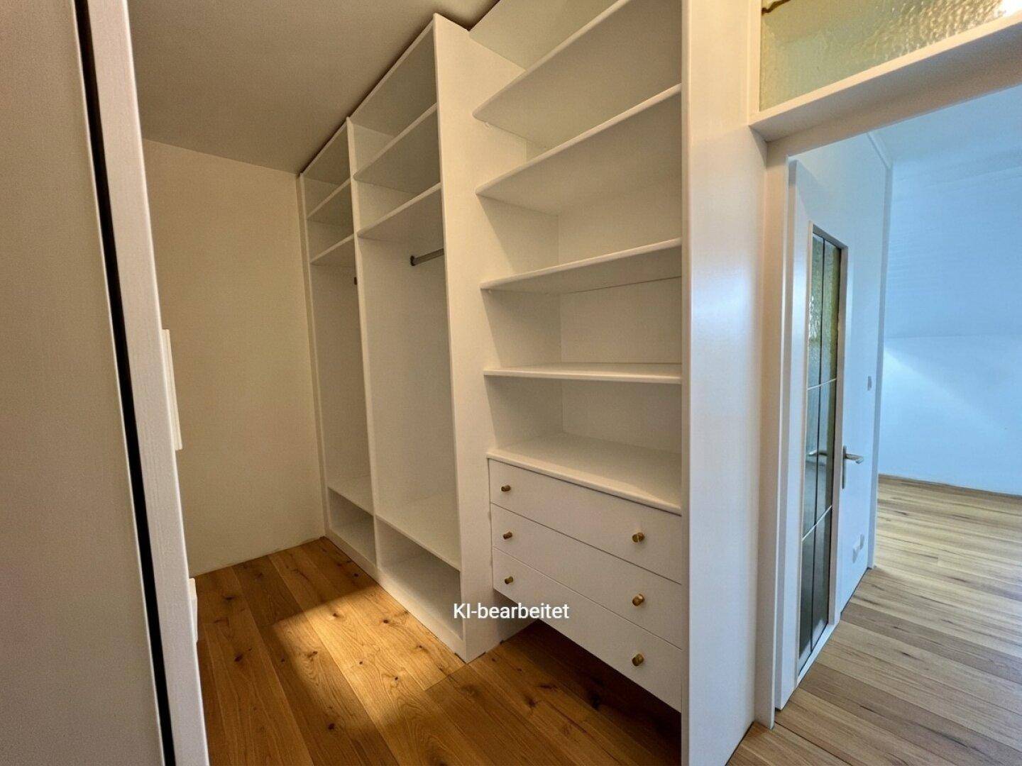 Praktischer begehbarer Kleiderschrank mit weißen Regalen und Schubladen.