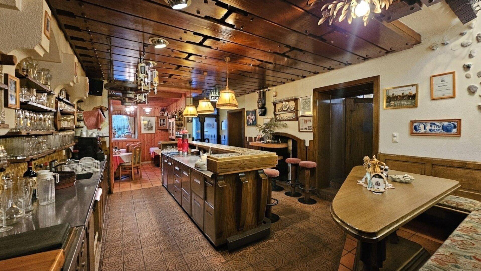 Traditioneller Barbereich mit Holzelementen, gemütlichen Sitzgelegenheiten und vielen Gläsern.