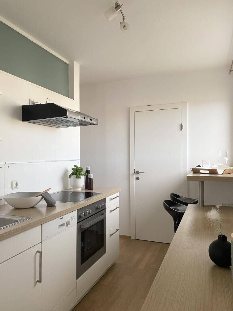 Küchenzeile mit integriertem Backofen, Kochfeld und Spülmaschine.