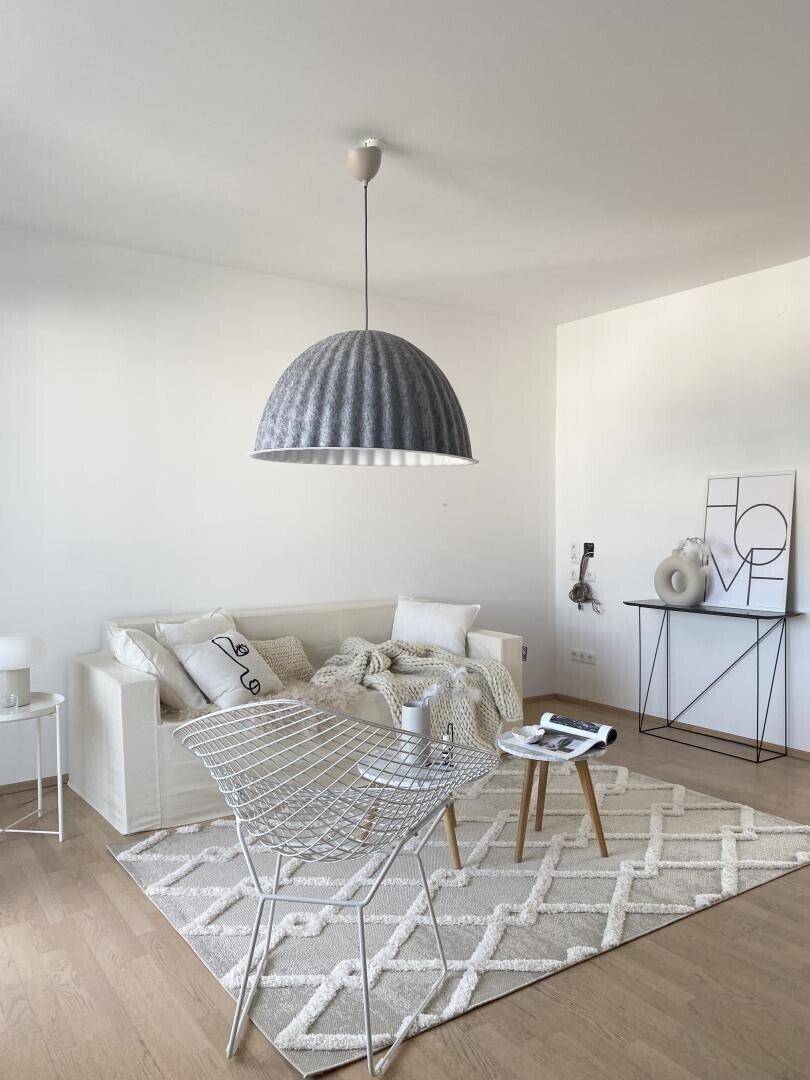 Gemütliches Wohnzimmer mit hellem Holzboden und stilvoller Einrichtung.