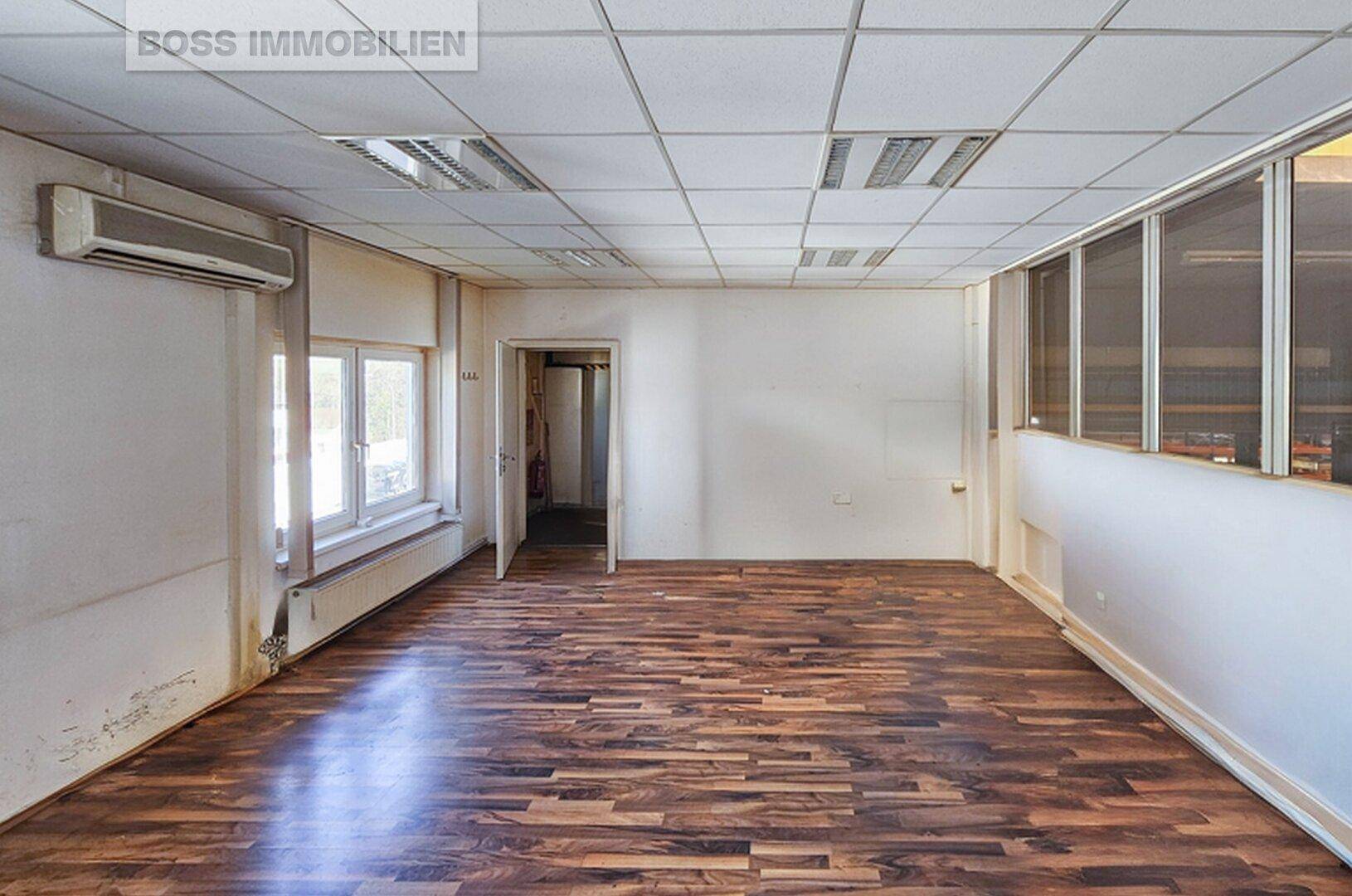 Helles Büro mit Laminatboden, abgehängter Decke und Klimaanlage, bereit zur individuellen Gestaltung.
