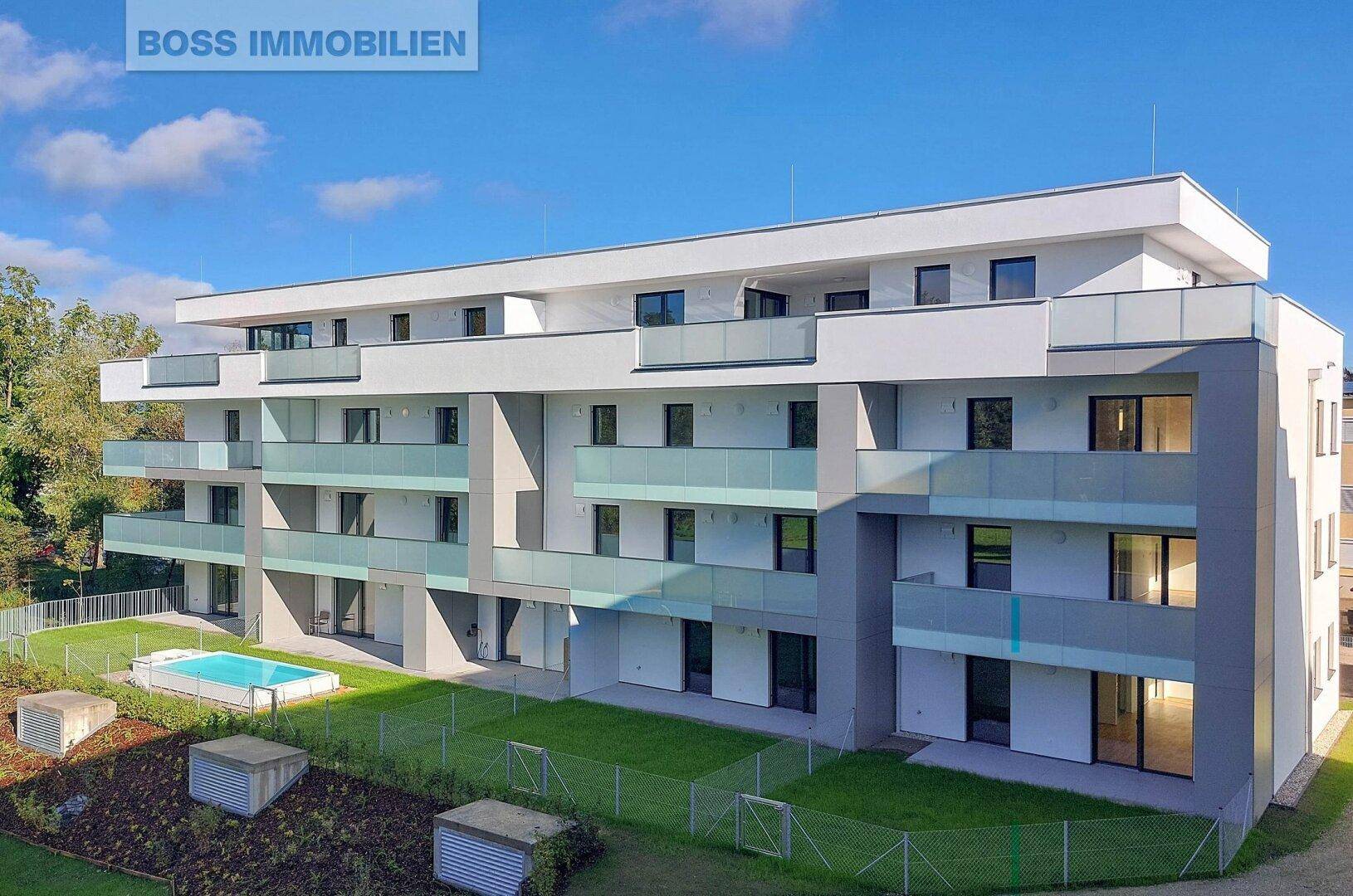 Moderne Wohnanlage mit Balkonen, kleinen Gärten und einem Gemeinschaftspool im Freien.