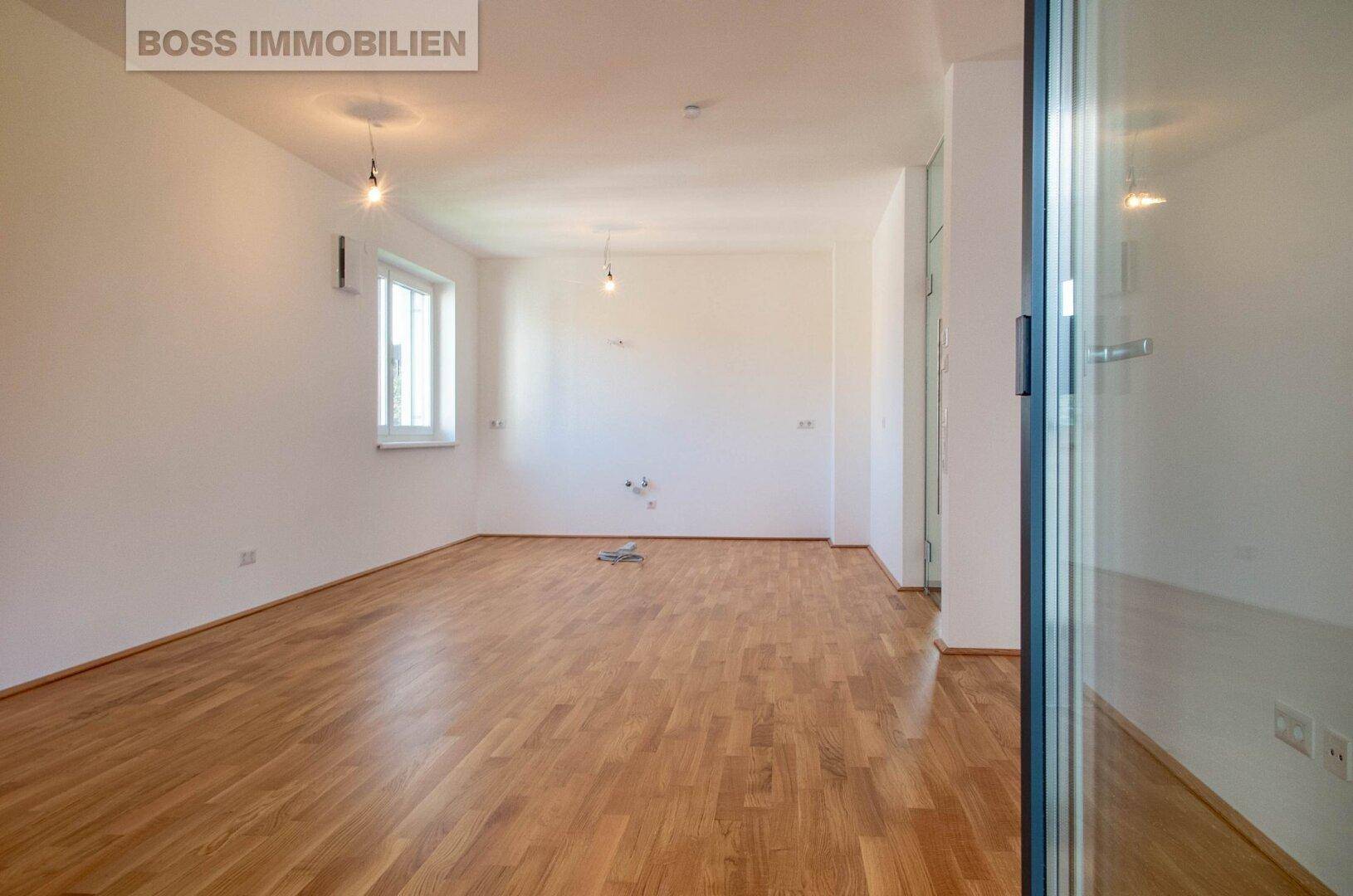 Heller, leerer Raum mit Parkettboden und einem Fenster, bereit zur individuellen Gestaltung.