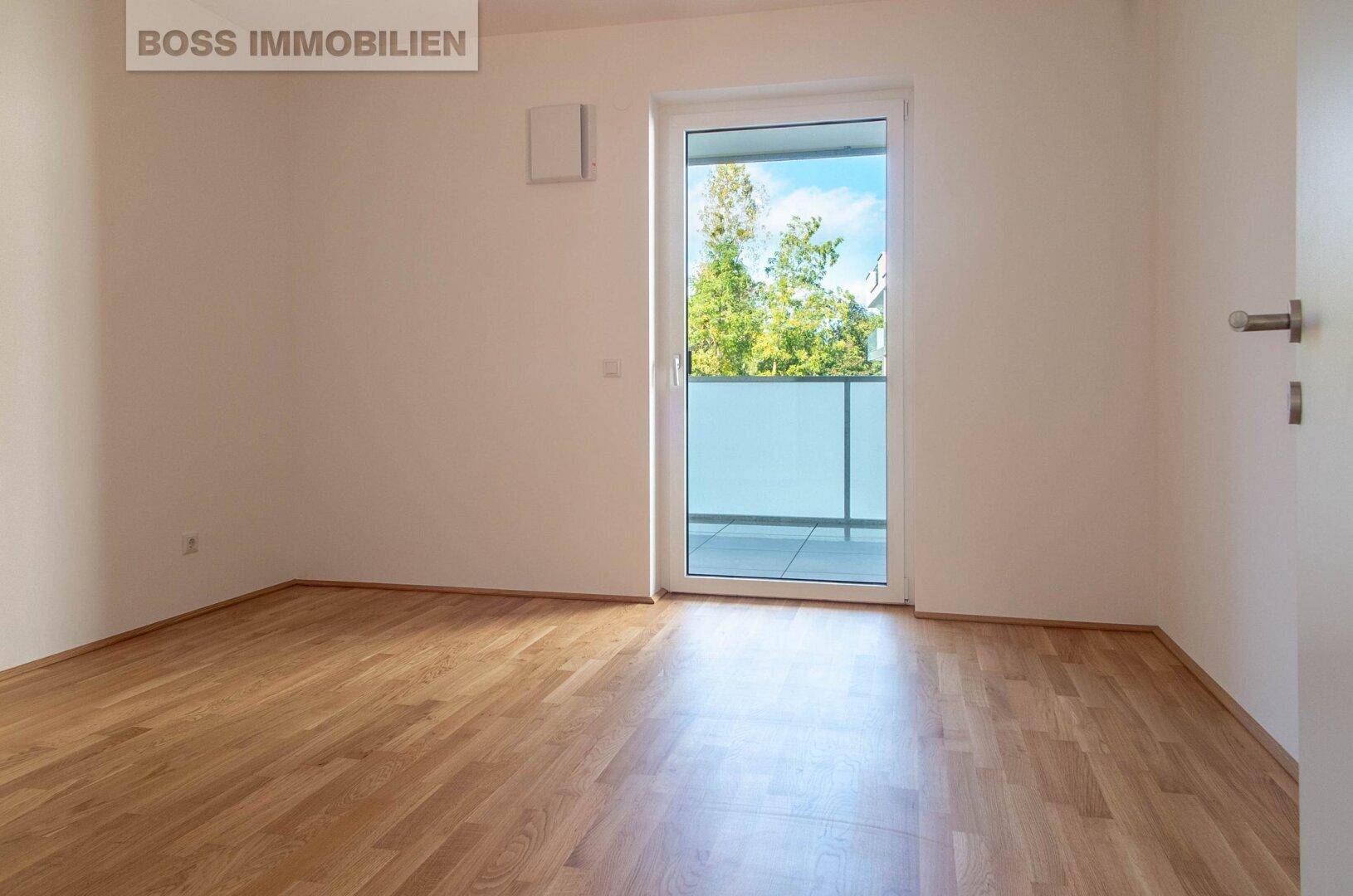 Helles Schlafzimmer mit Parkettboden und direktem Zugang zu einem privaten Balkon.