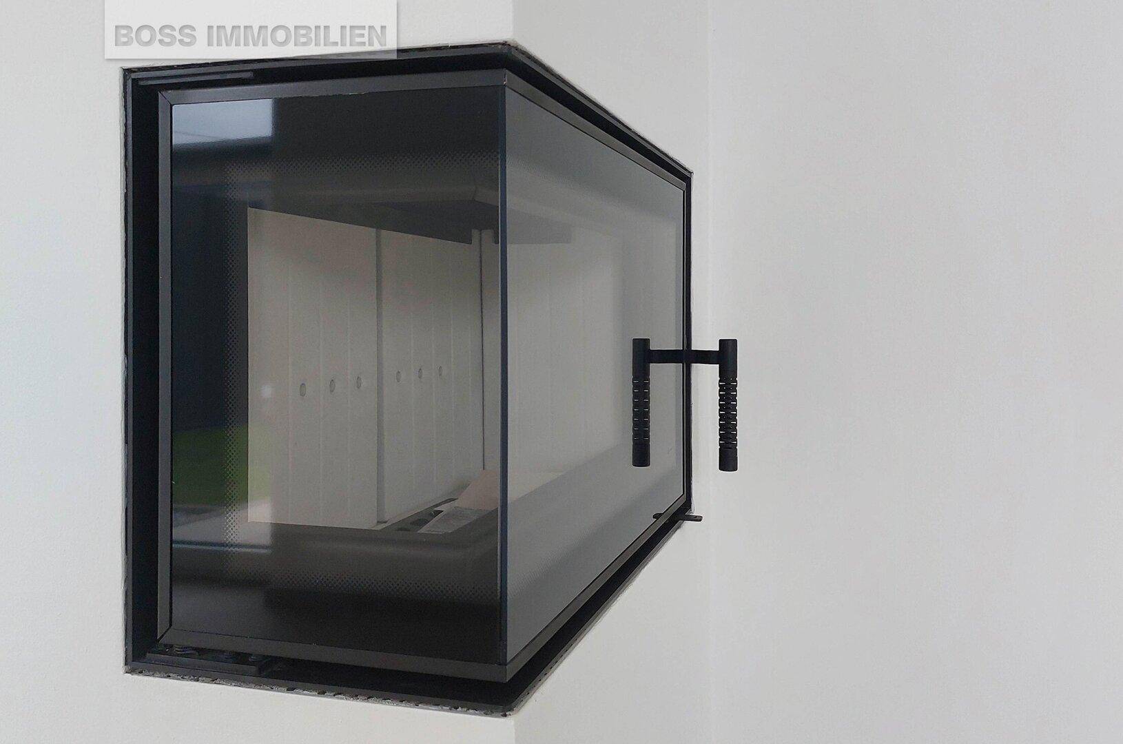 Moderner Eckkamin mit Glasfronten, der eine gemütliche Atmosphäre schafft.