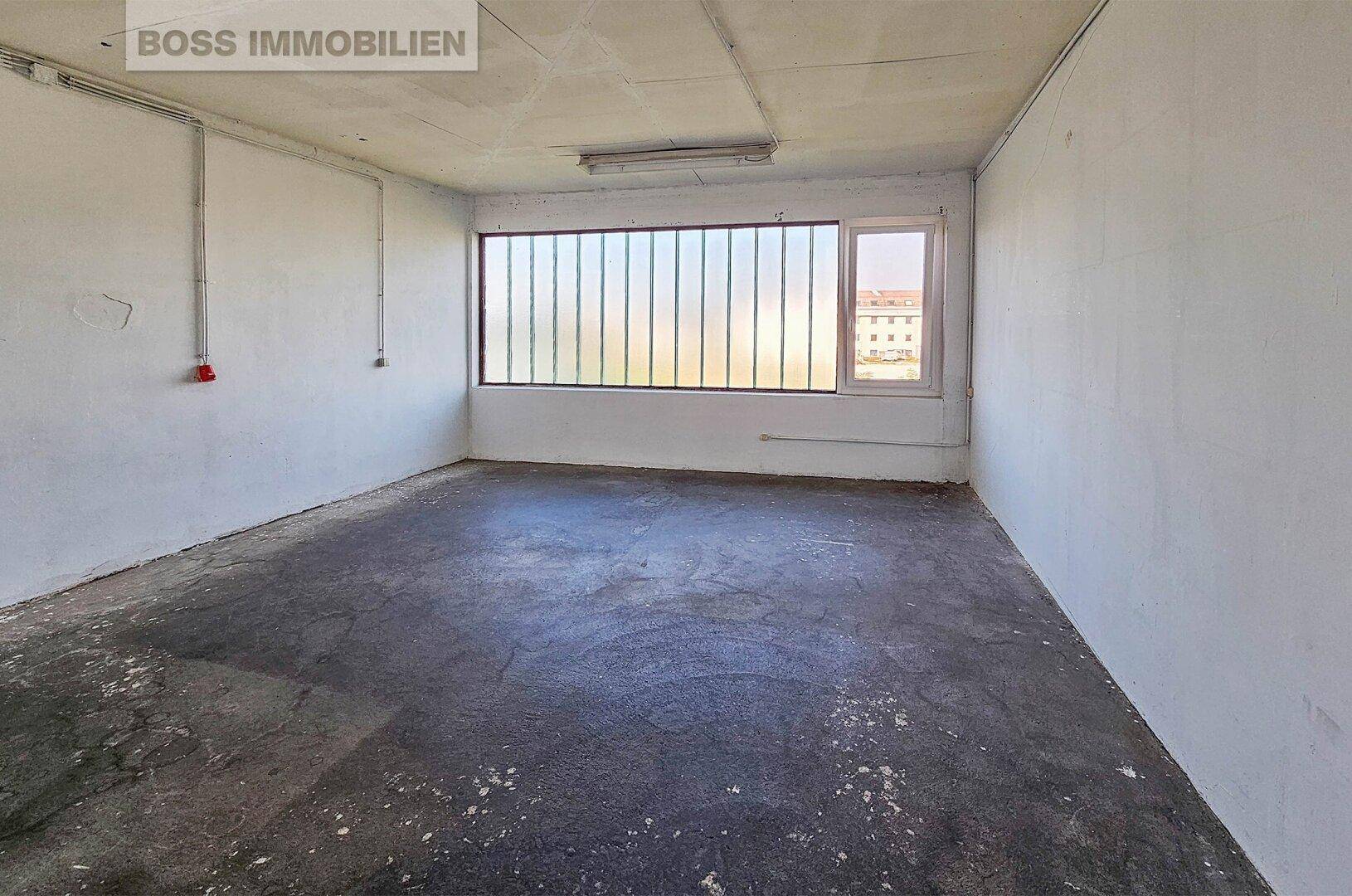 Kleinerer Lagerraum mit Betonboden und einem Fenster, geeignet für zusätzliche Abstellfläche.