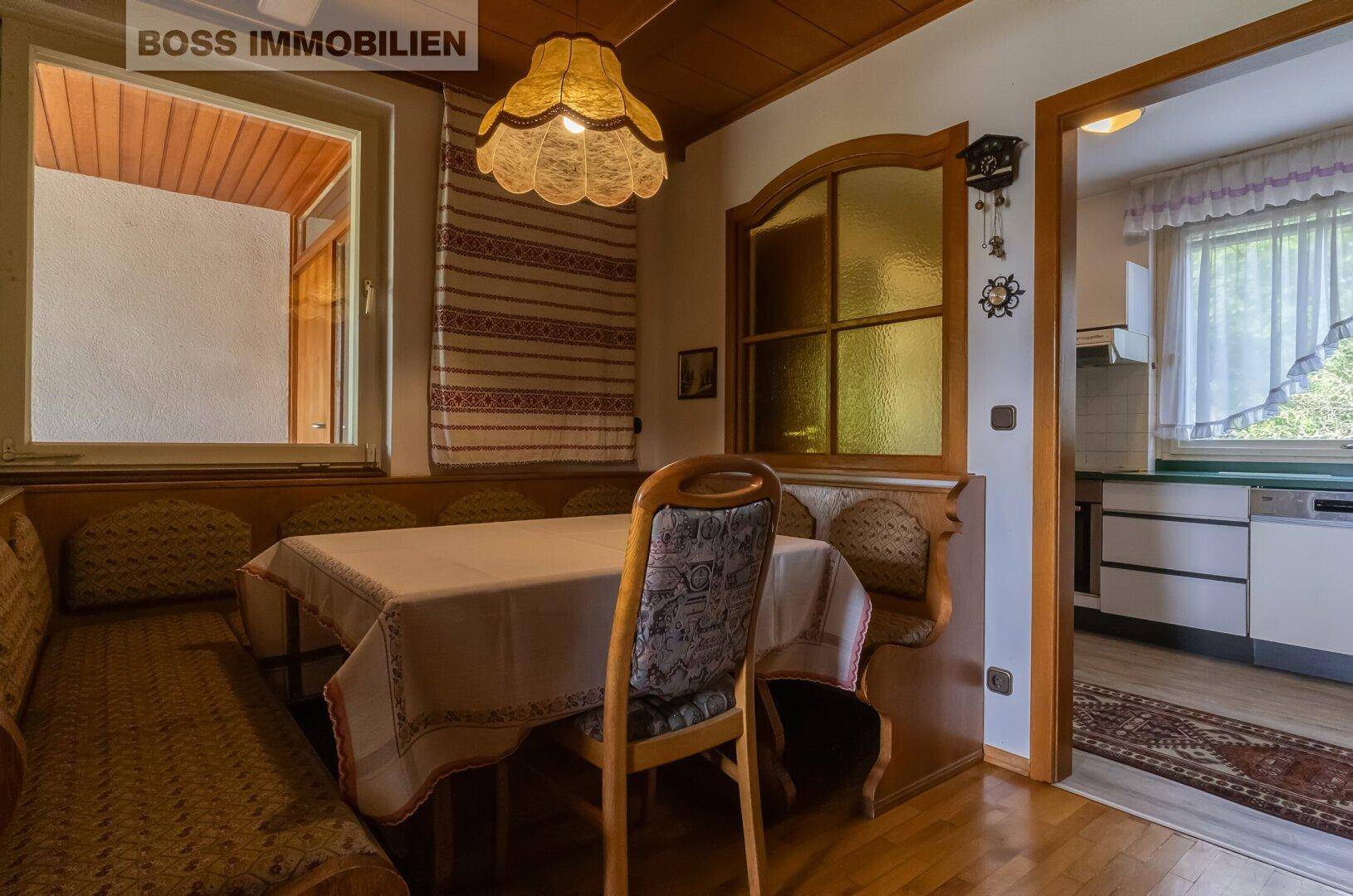 Gemütlicher Essbereich mit Holzbänken, Esstisch und traditioneller Einrichtung.
