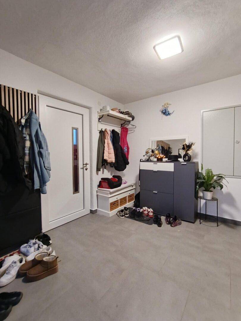Funktionaler Flur mit Schuhschrank, Spiegel und weiterer Garderobenlösung für den Eingangsbereich.