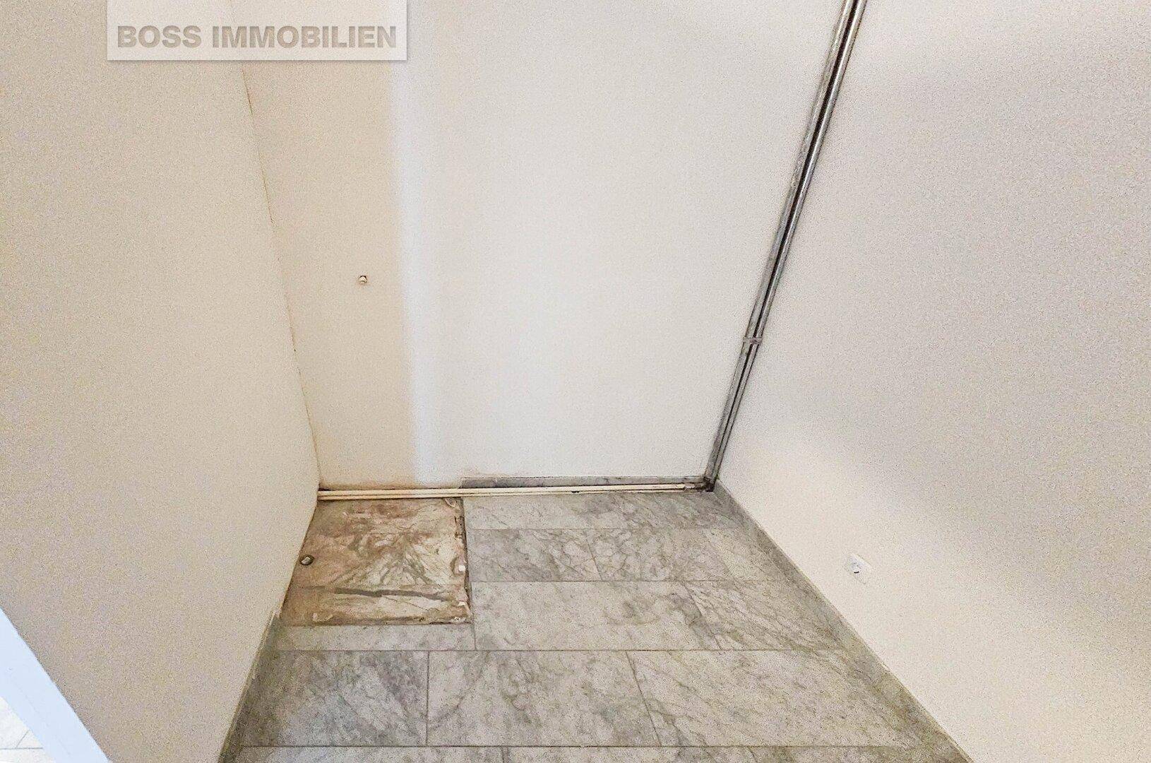 Kleiner Abstellraum mit gefliestem Boden und schrägen Wänden, ideal für Lagerzwecke.