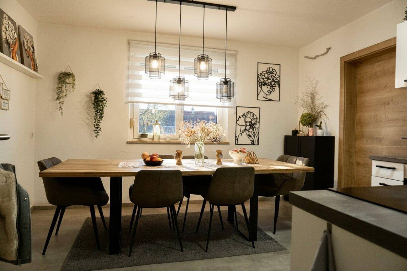 Gemütlicher Essbereich mit Holztisch, modernen Hängelampen und Fenster.