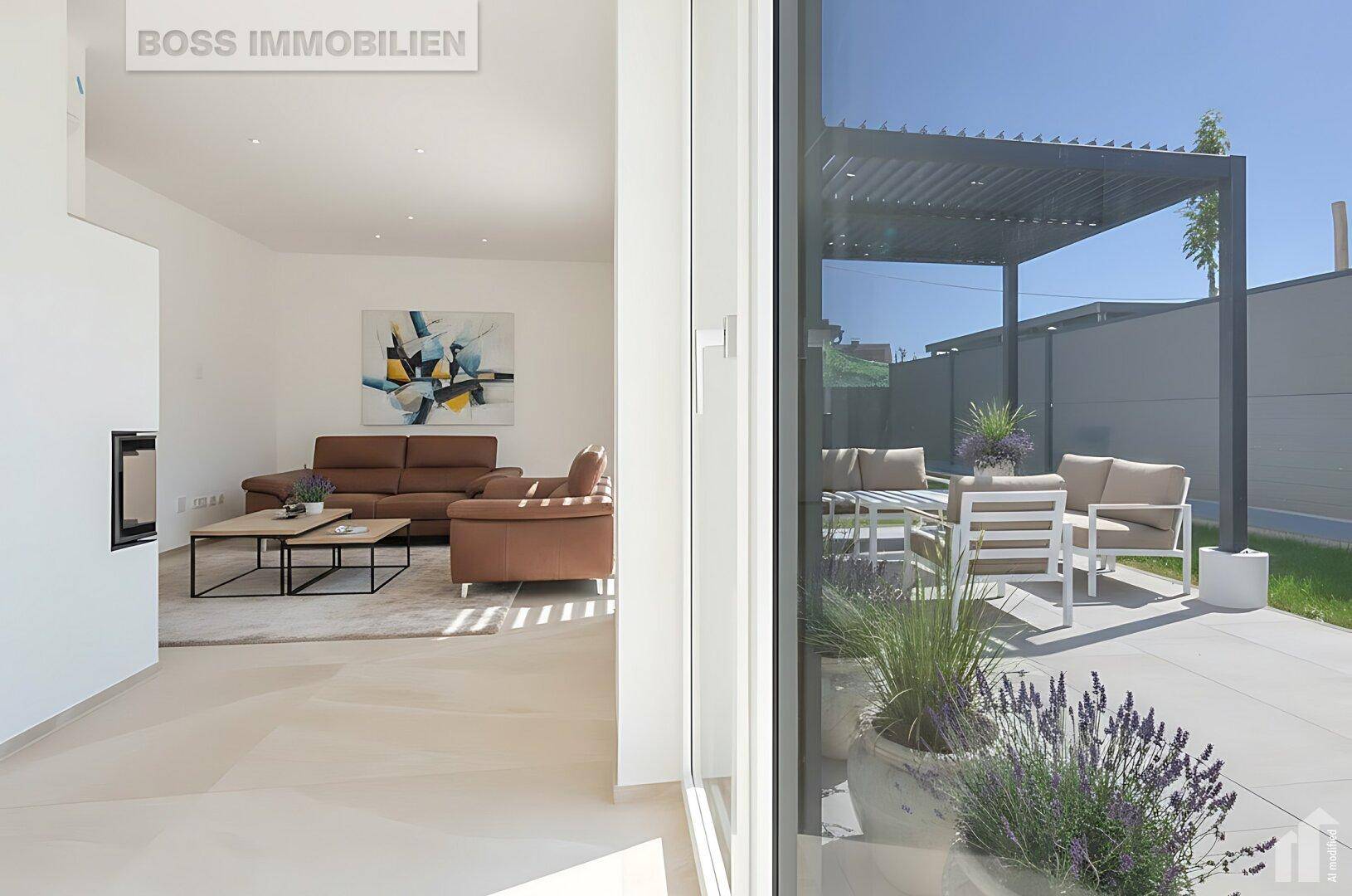 Helles Wohnzimmer mit Kamin und Blick auf die möblierte Terrasse mit Pergola.