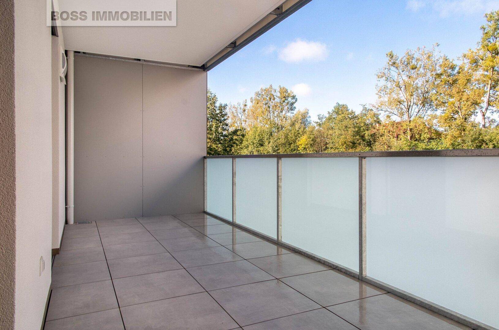 Geräumiger Balkon mit Fliesenboden und Blick ins Grüne, ideal zum Entspannen.