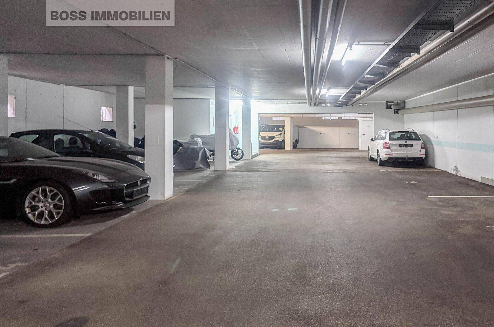 Tiefgarage mit mehreren geparkten Fahrzeugen und Betonstützen.