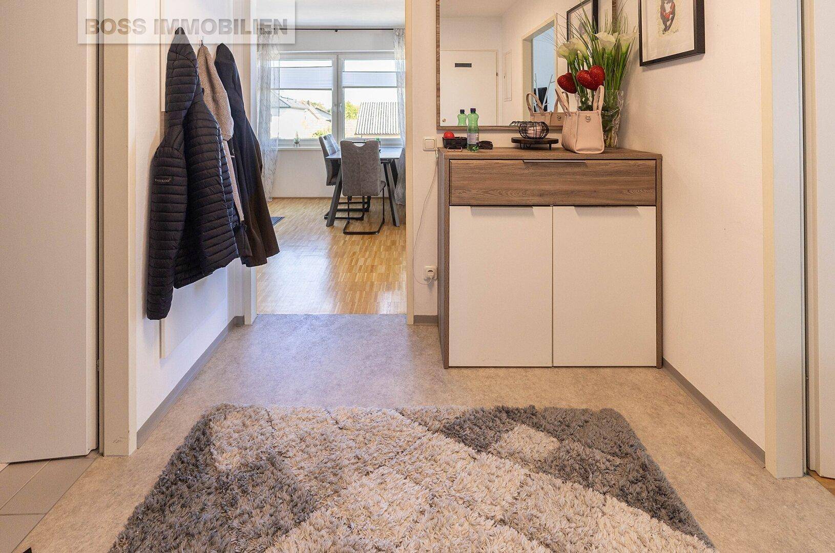 Eingangsbereich mit Garderobe, Schuhschrank und Spiegel, offen zum Wohnbereich.