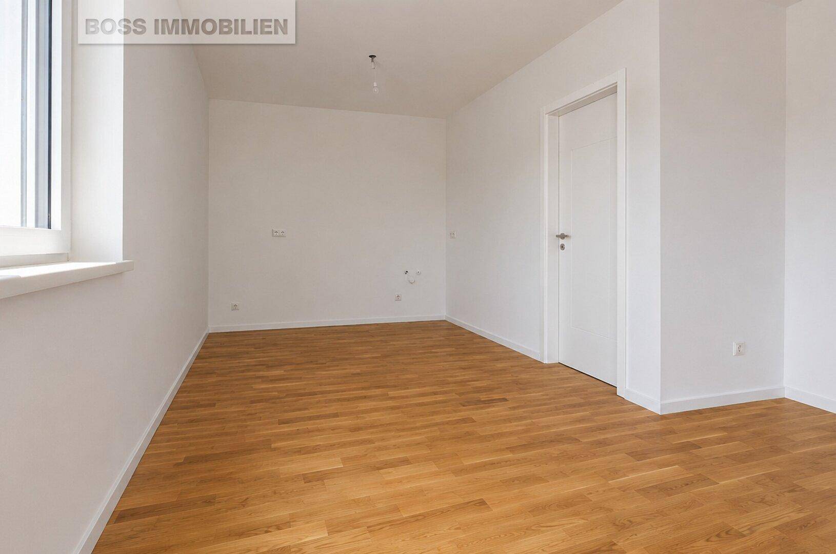 Leerer Raum mit Holzboden und weißen Wänden, bereit für individuelle Gestaltung.